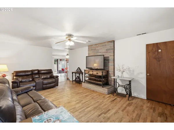 a living room with furniture and a flat screen tv with wooden floor