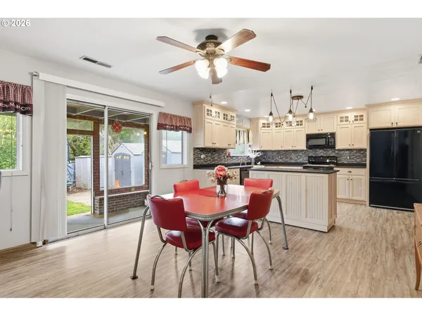 a kitchen with stainless steel appliances kitchen island granite countertop a dining table chairs and granite counter tops