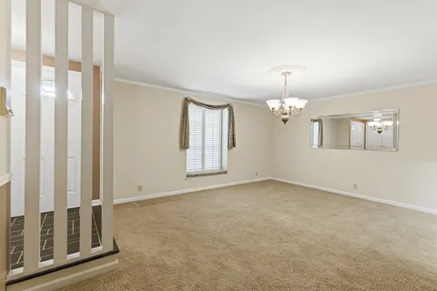 an empty room with windows and chandelier