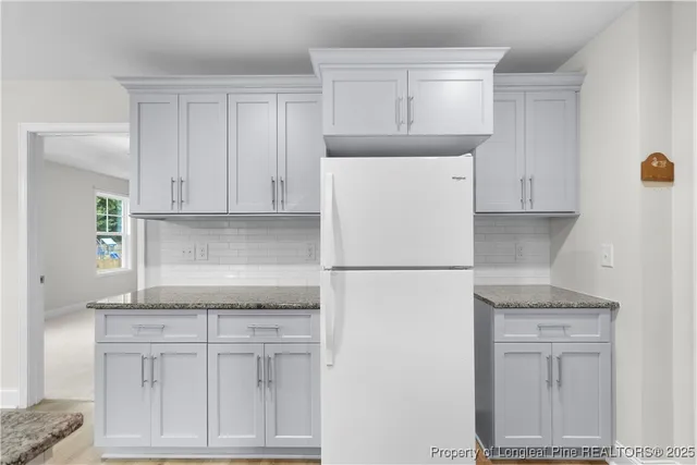 a white refrigerator freezer sitting inside of a kitchen