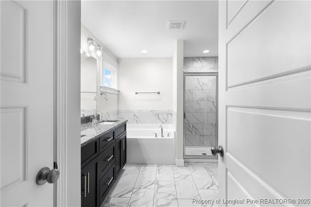 a bathroom with a granite countertop sink a toilet and shower