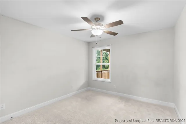 an empty room with a window and a ceiling fan