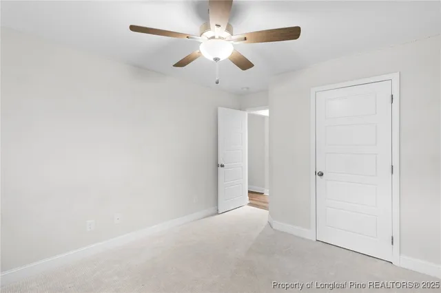 an empty room with chandelier fan