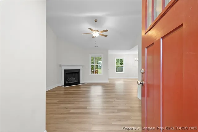 a view of an empty room with a fireplace and a window
