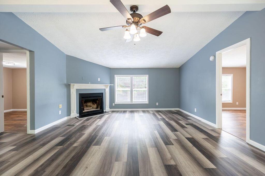 4342 County Line Road Patrick Springs, VA 24133 - Photo 14 of 34 wooden floor fireplace and windows in an empty room