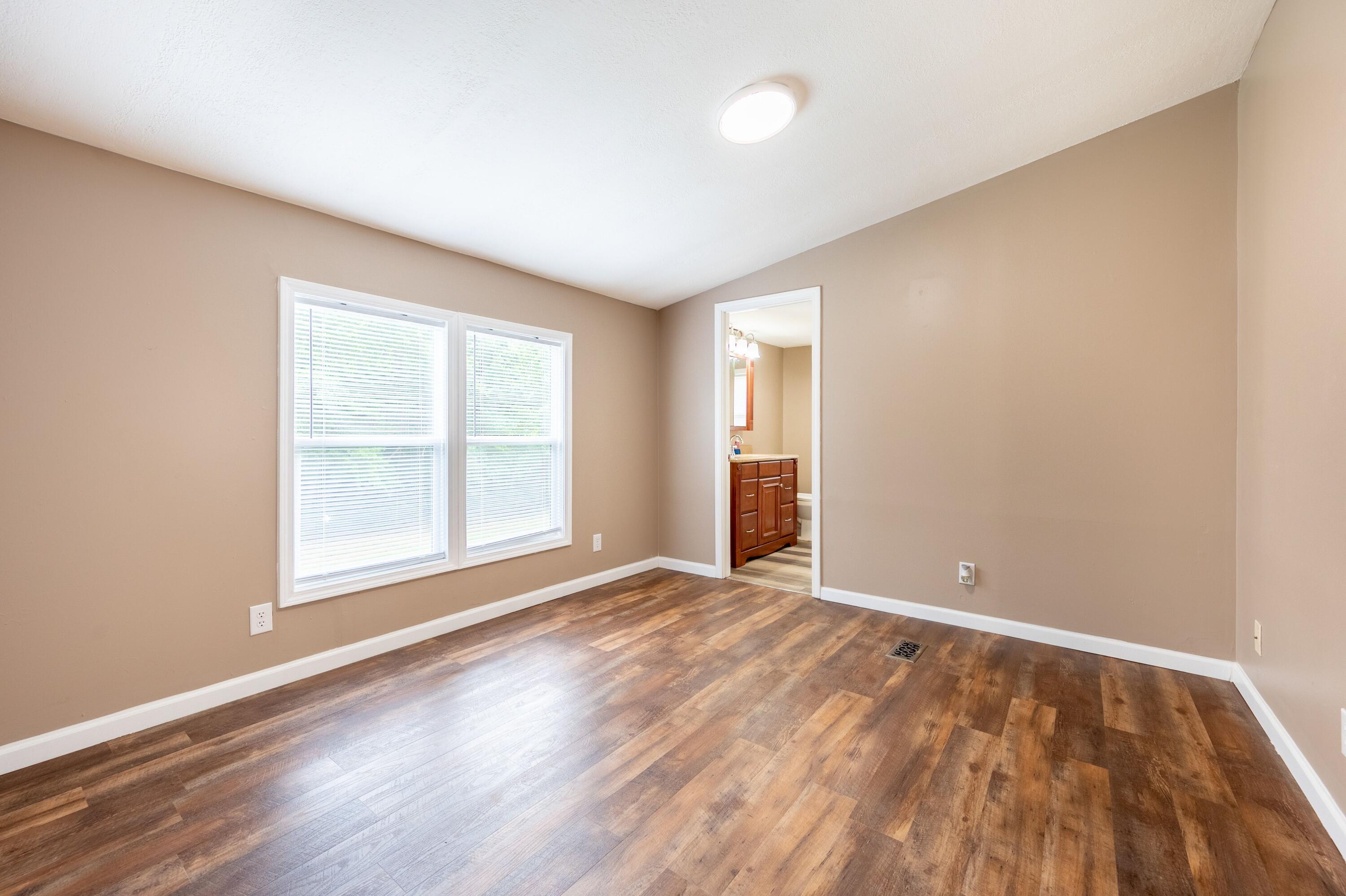 4342 County Line Road Patrick Springs, VA 24133 - Photo 22 of 34 an empty room with wooden floor and windows