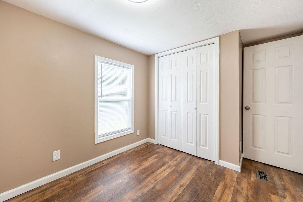 4342 County Line Road Patrick Springs, VA 24133 - Photo 26 of 34 an empty room with wooden floor and windows
