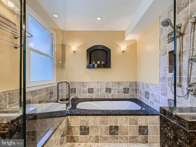 a bathroom with a granite countertop sink a mirror and shower