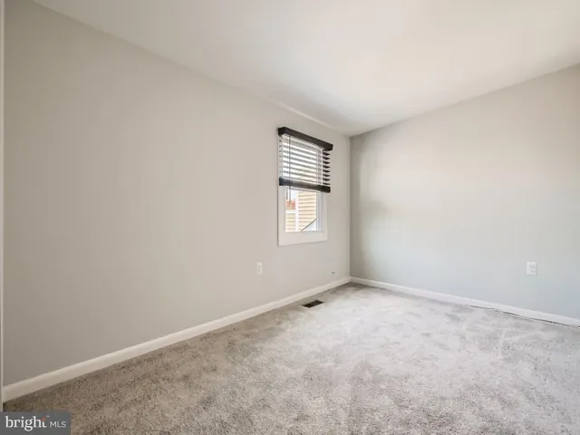 a bathroom with a toilet a sink a mirror and a window