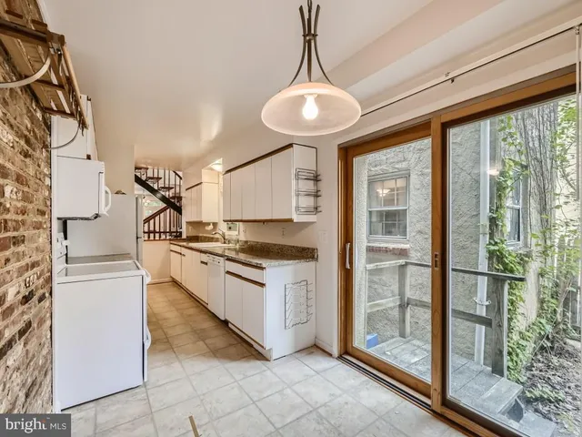 a large kitchen with stainless steel appliances granite countertop a stove and a refrigerator