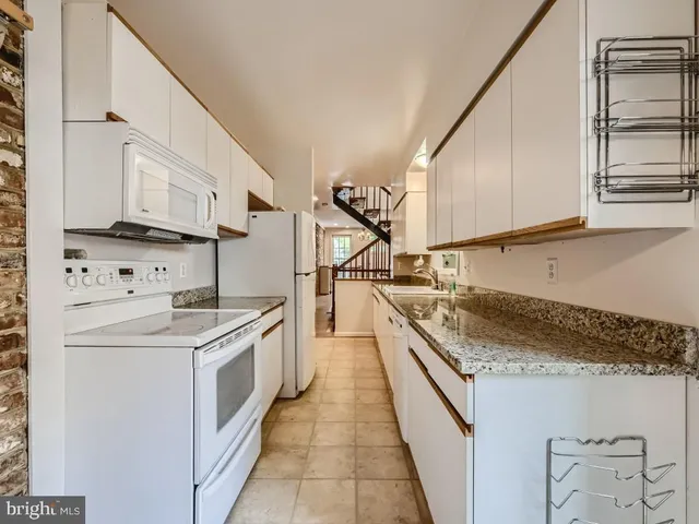 a kitchen with stainless steel appliances granite countertop a sink and a stove