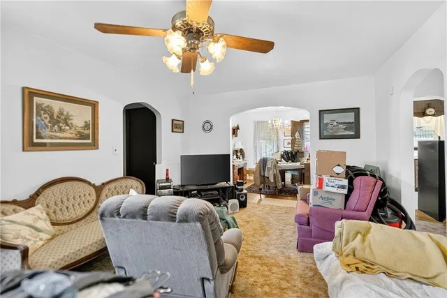 a living room with furniture a chandelier and a flat screen tv