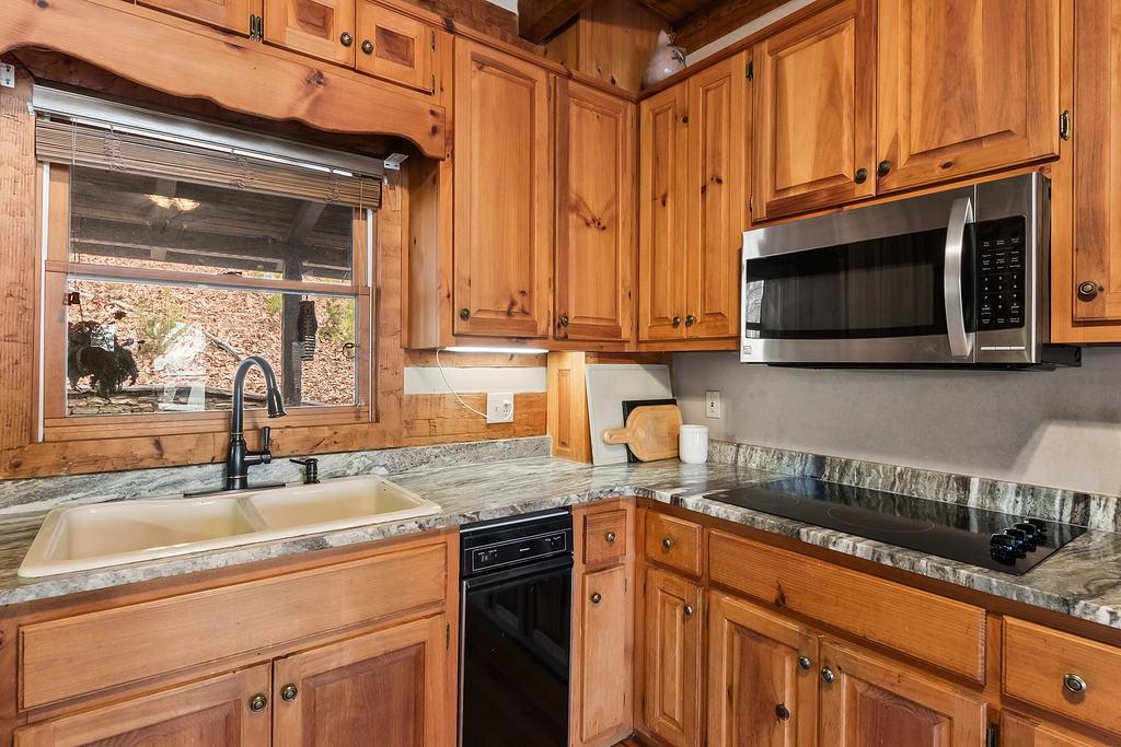 192 Grassy Knob Court Jasper, GA 30143 - Photo 35 of 88 a kitchen with granite countertop a sink stainless steel appliances wooden cabinets and a counter top space