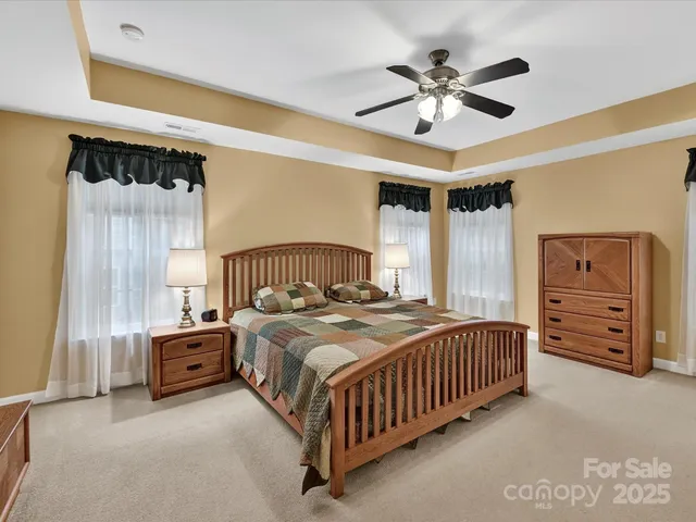 a bedroom with a bed a chandelier and a dresser