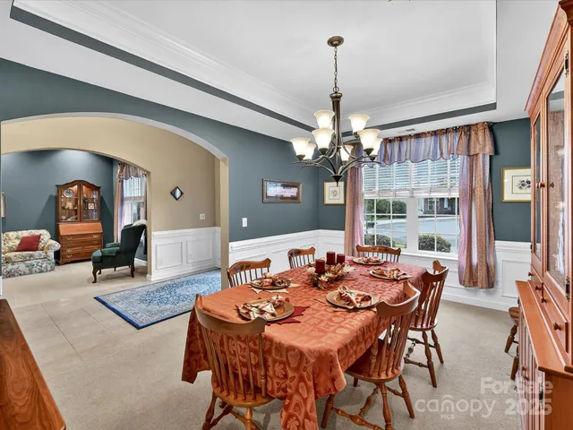 a dining room with furniture a chandelier and window