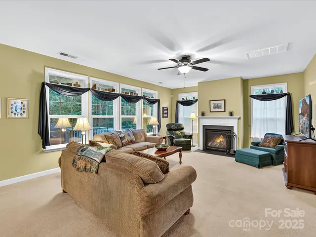 a living room with furniture fireplace and a large window
