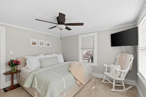 a bedroom with a bed tv and chair