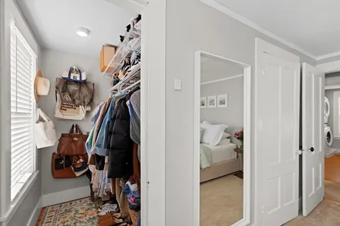 a view of walk in closet with clothes and shoes