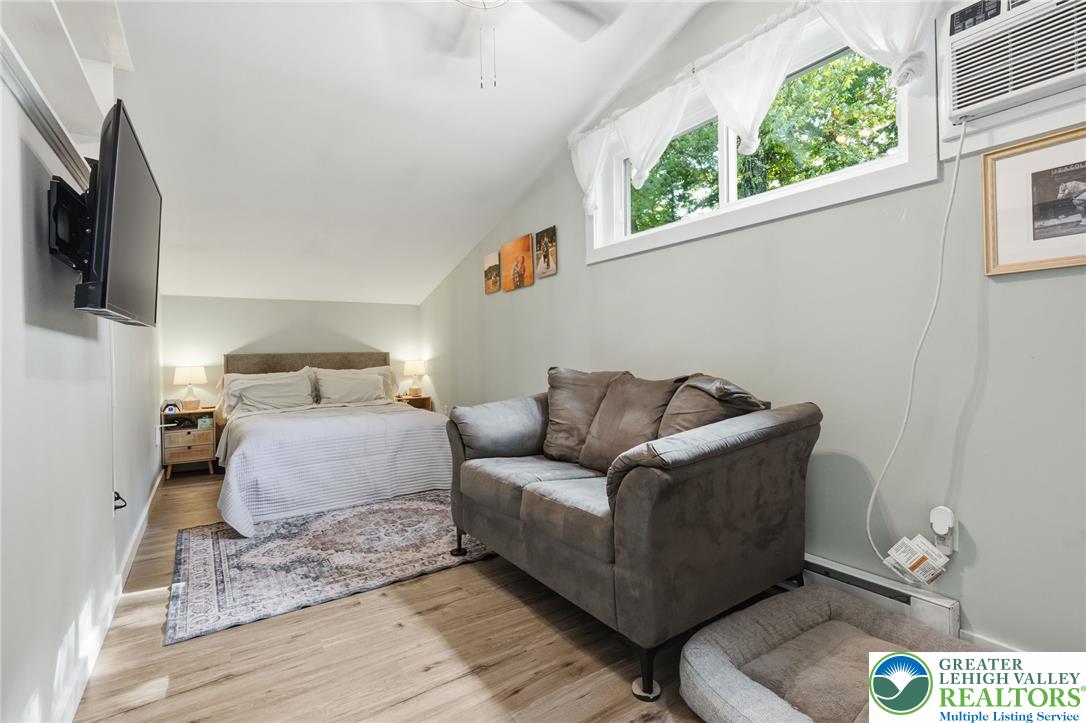 9033 Loop Road Slatington, PA 18080 - Photo 28 of 53 An inviting bedroom features warm wood flooring and a large window overlooking lush trees.