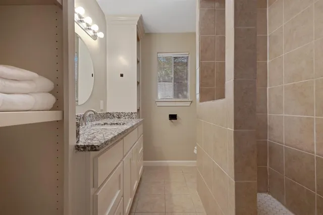 a bathroom with a granite countertop sink a toilet and shower