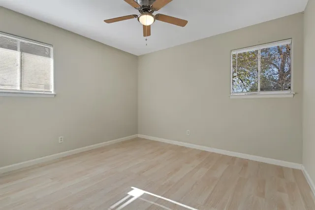 a view of an empty room with a window and a ceiling fan