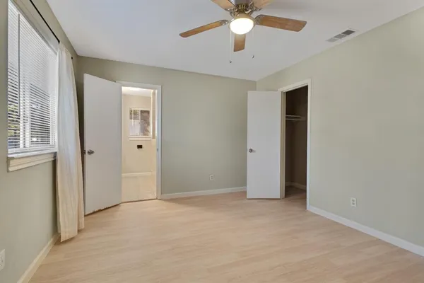 an empty room with a ceiling fan and a window