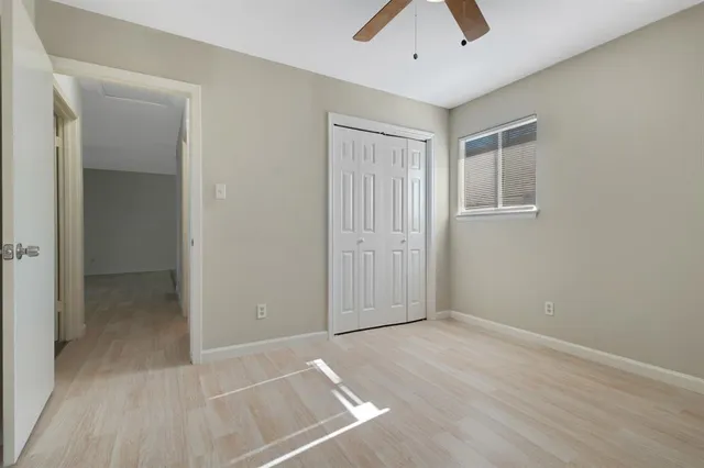 an empty room with closet and a chandelier fan