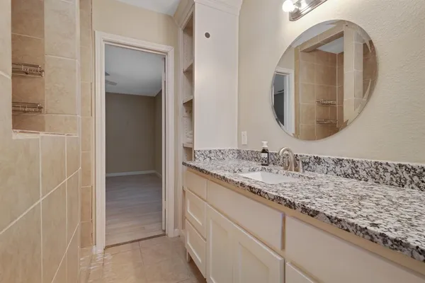 a bathroom with a granite countertop sink and a mirror