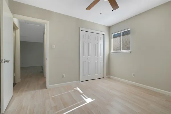 an empty room with closet and a chandelier fan