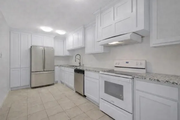 a kitchen with granite countertop white cabinets and white stainless steel appliances