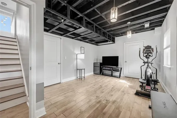 a view of a room with gym equipment and a flat screen tv