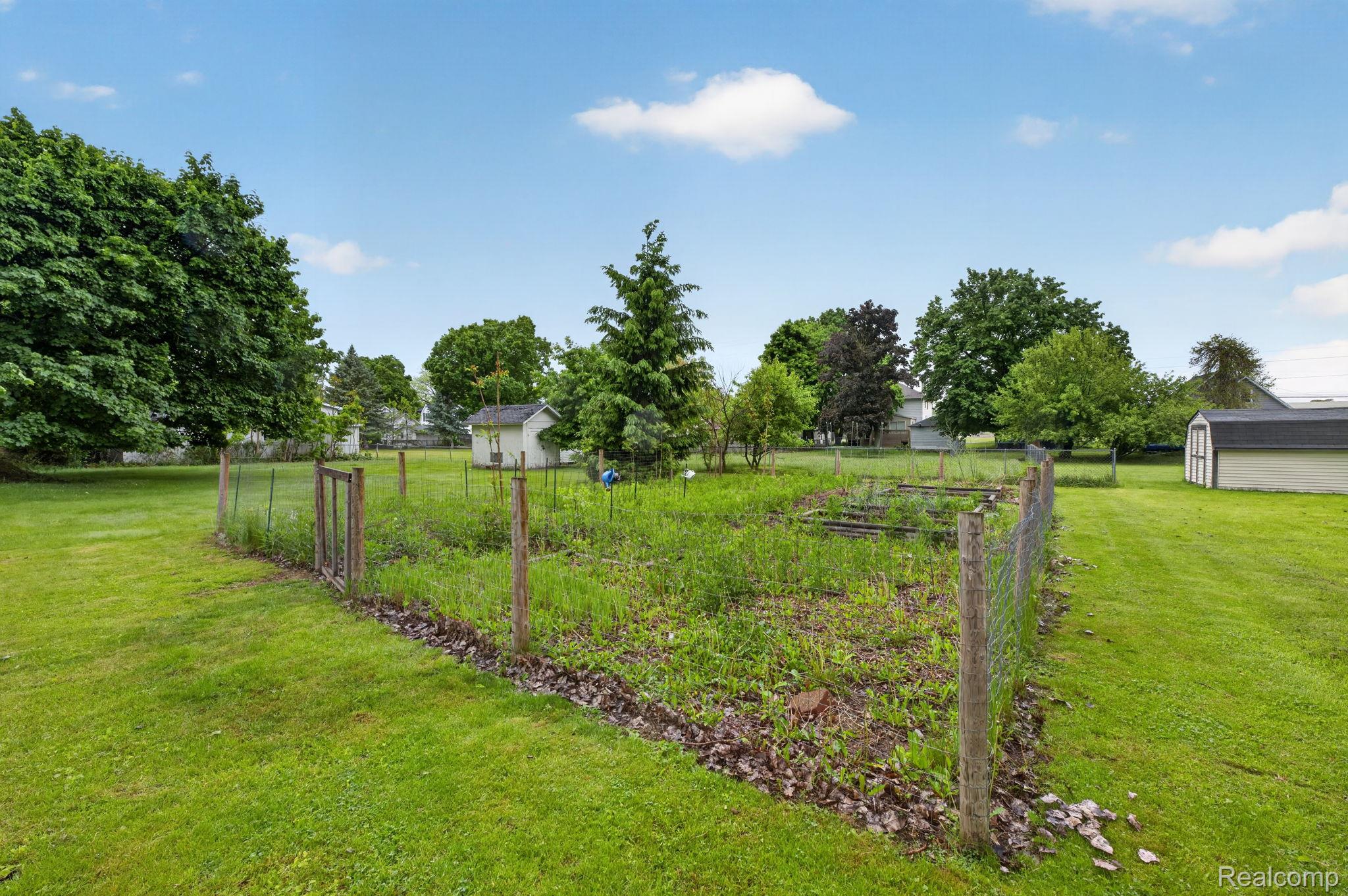 304 West Ridge Street Owosso, MI 48867 - Photo 32 of 45 View of yard featuring a vegetable garden and a shed