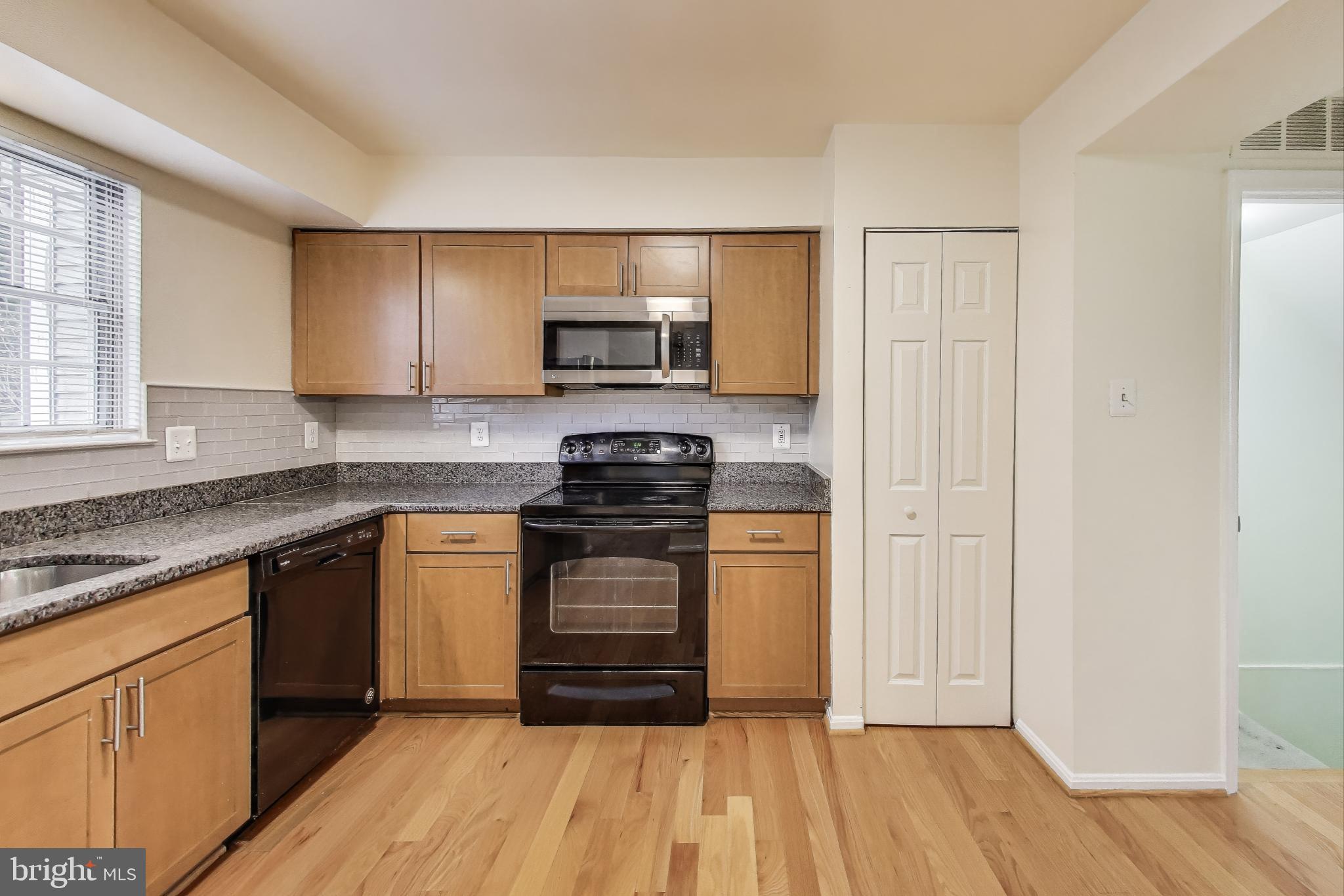 16 Tabiona Court Silver Spring, MD 20906 - Photo 11 of 34 a kitchen with stainless steel appliances granite countertop a stove a sink and a microwave