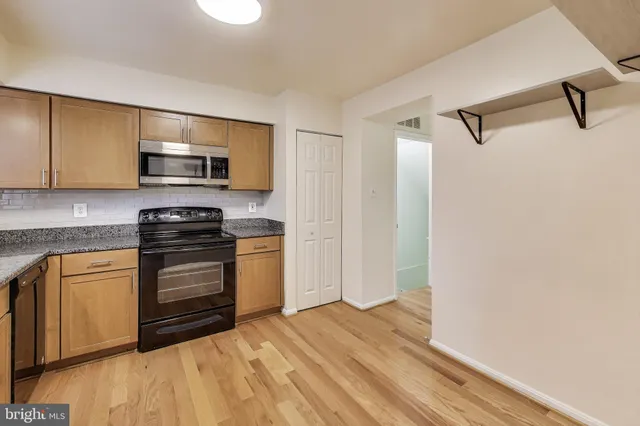 a kitchen with stainless steel appliances a stove microwave and sink