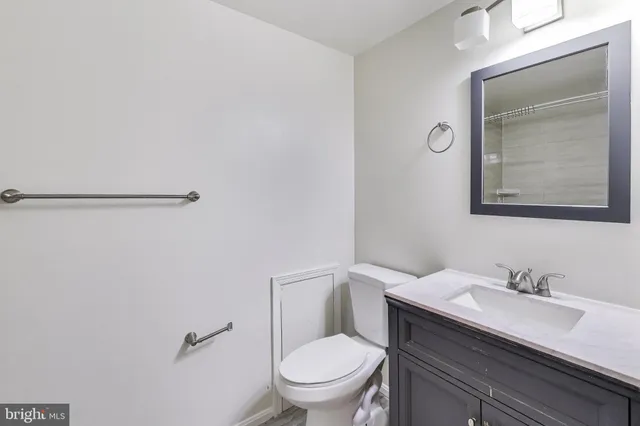 a bathroom with a granite countertop sink a toilet and a mirror