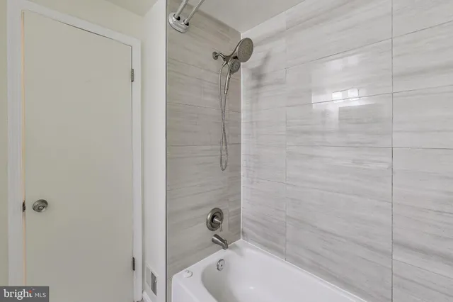 a bathroom with a tub shower and a sink