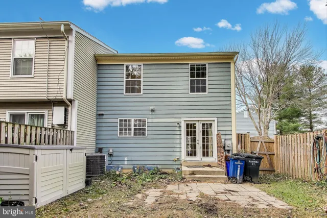 a view of a house with a yard and wooden fence