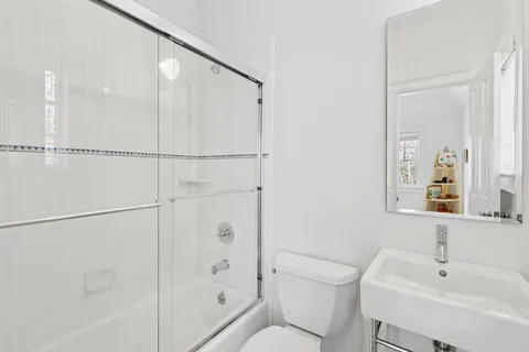 a bathroom with a bathtub shower sink vanity and toilet