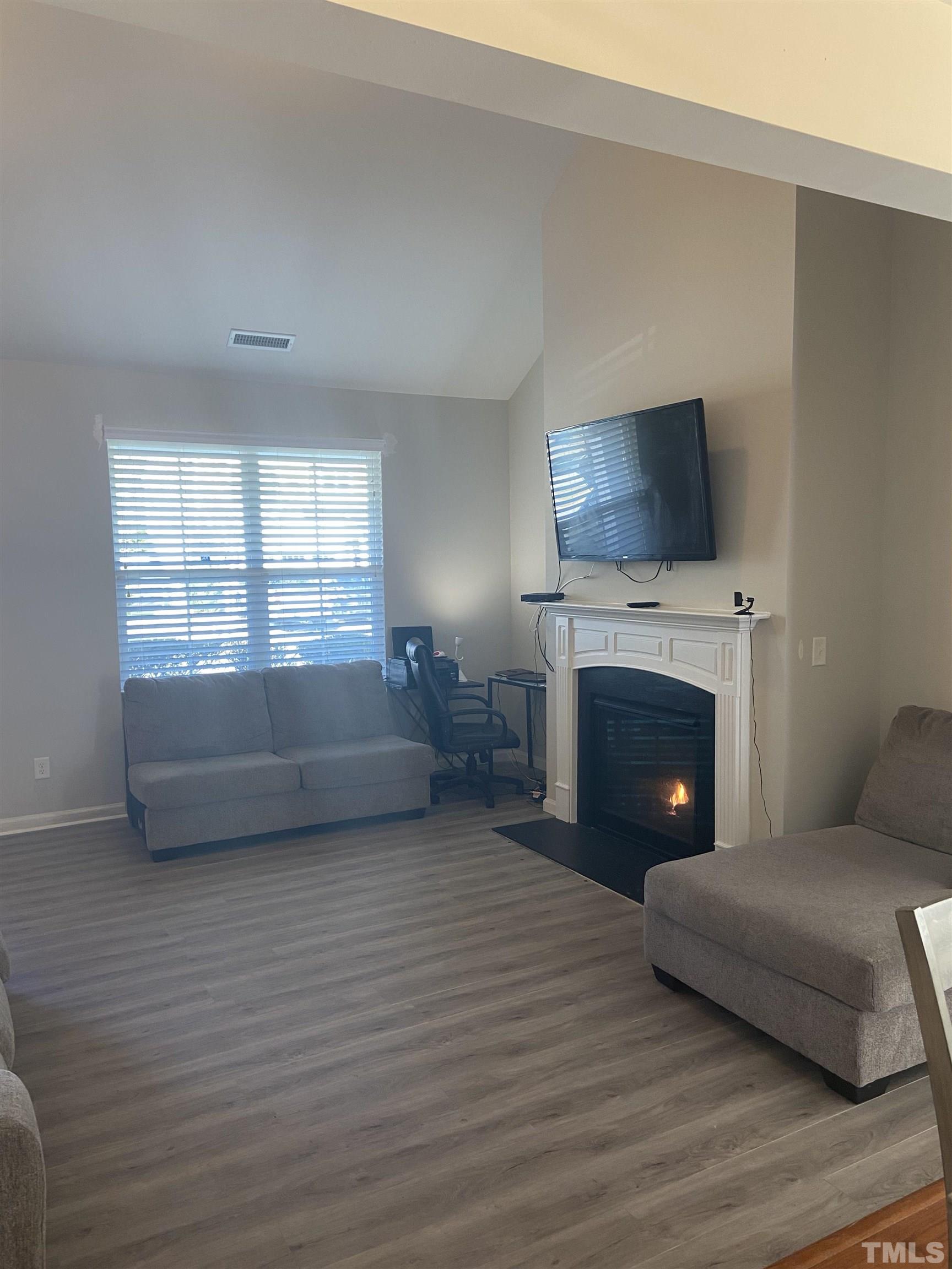 3532 Eastern Branch Road Raleigh, NC 27610 - Photo 8 of 36 a living room with furniture a flat screen tv and a fireplace