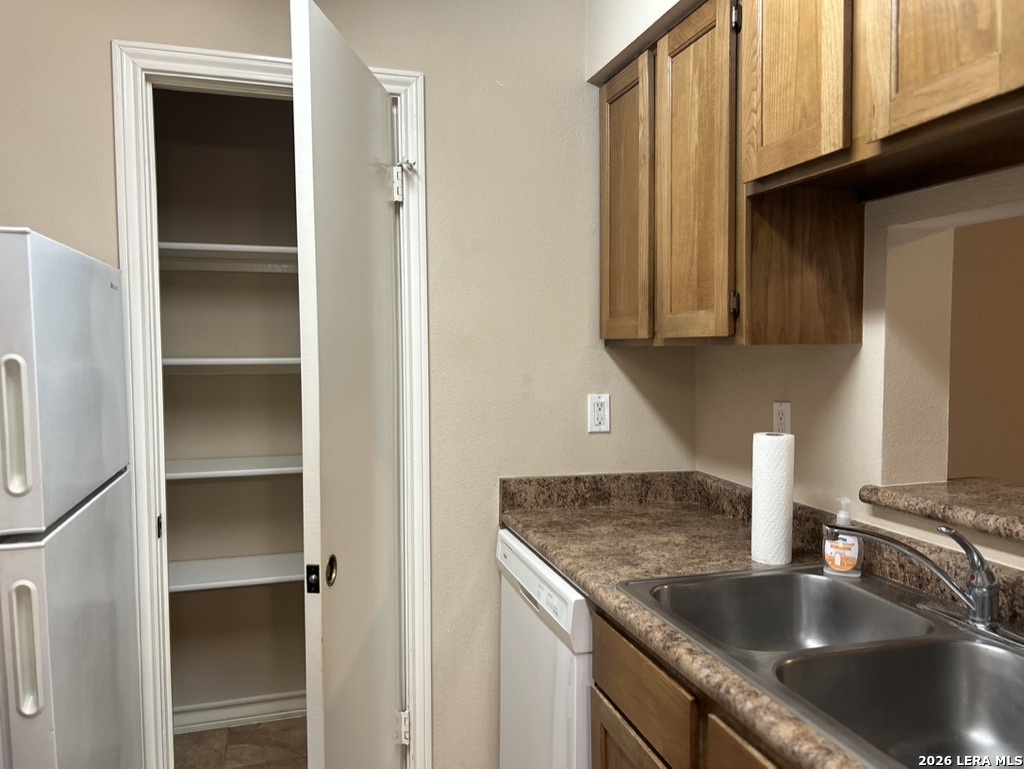 13018 Heimer Road, Unit 710 San Antonio, TX 78216 - Photo 10 of 27 a kitchen with granite countertop a sink and a refrigerator