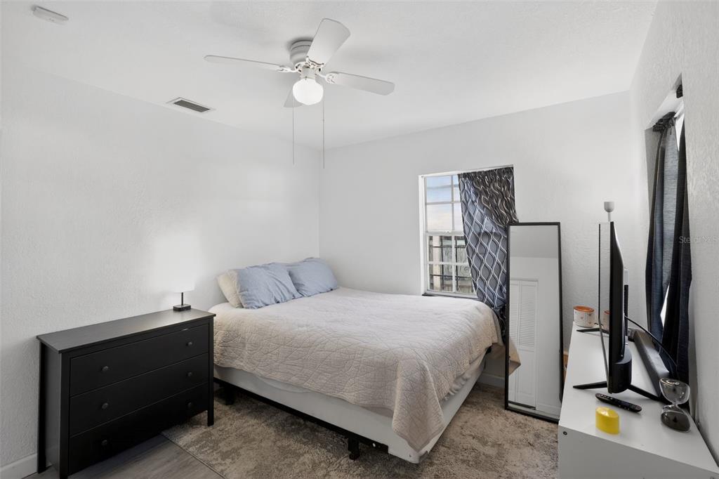 700 28th Street Orlando, FL 32805 - Photo 11 of 19 a bedroom with a bed a dresser and a chandelier