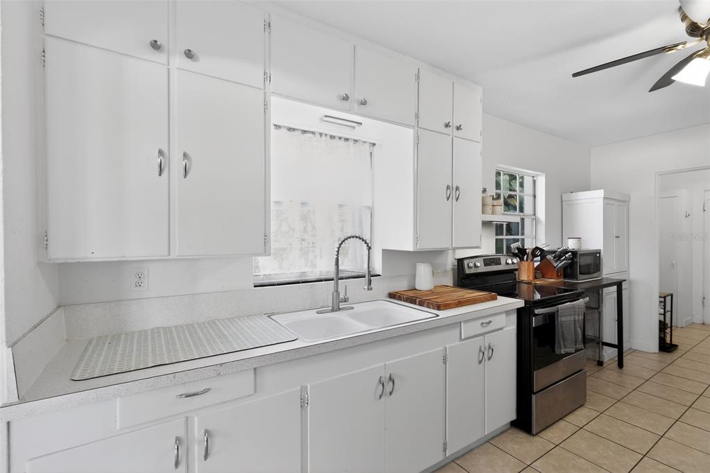 700 28th Street Orlando, FL 32805 - Photo 5 of 19 a kitchen with stainless steel appliances granite countertop a sink stove and cabinets