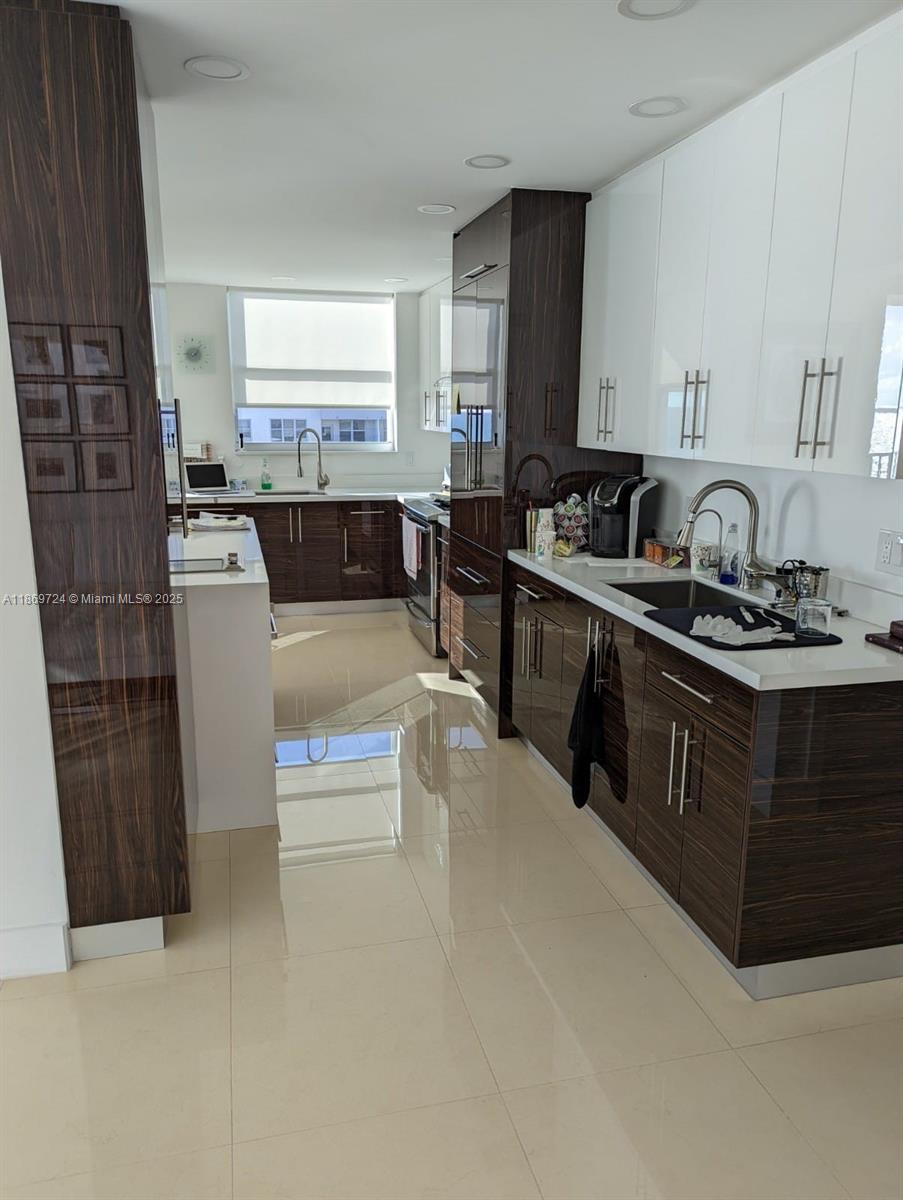 9273 Collins Avenue, Unit 1004 Surfside, FL 33154 - Photo 16 of 27 a kitchen with cabinets and window