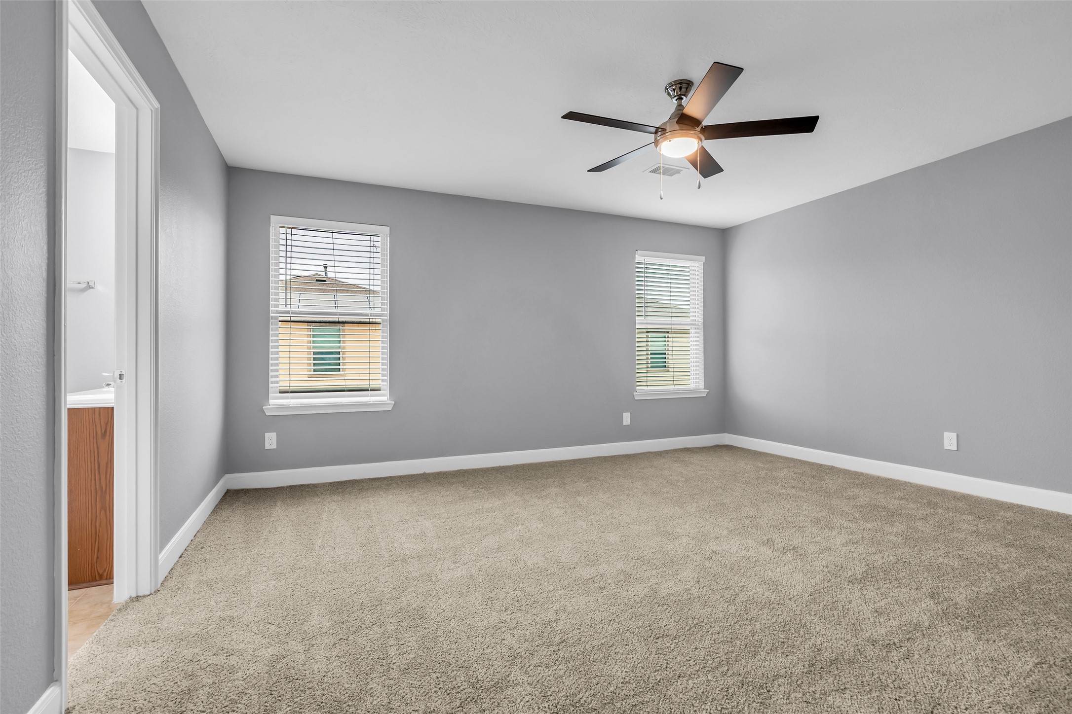 2707 Volute Houston, TX 77038 - Photo 17 of 28 Primary bedroom overlooking the backyard, featuring carpeted flooring and a bright, open feel.