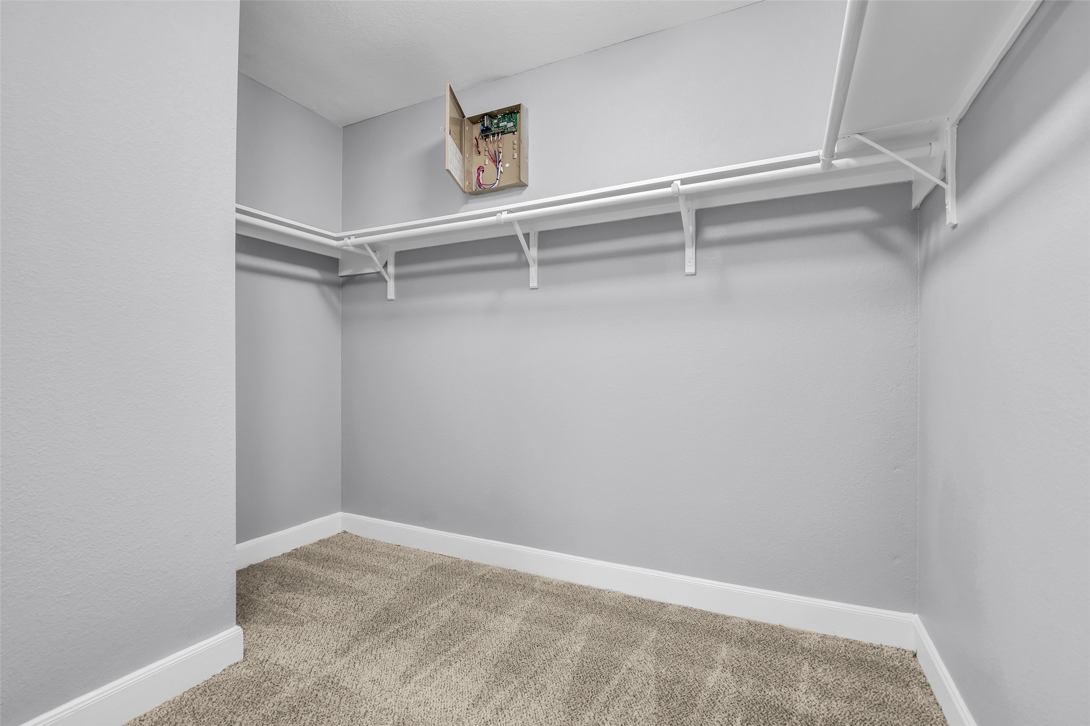 2707 Volute Houston, TX 77038 - Photo 20 of 28 Walk-in closet located in the primary bedroom, featuring built-in hanging racks and carpeted flooring for added comfort and organization.