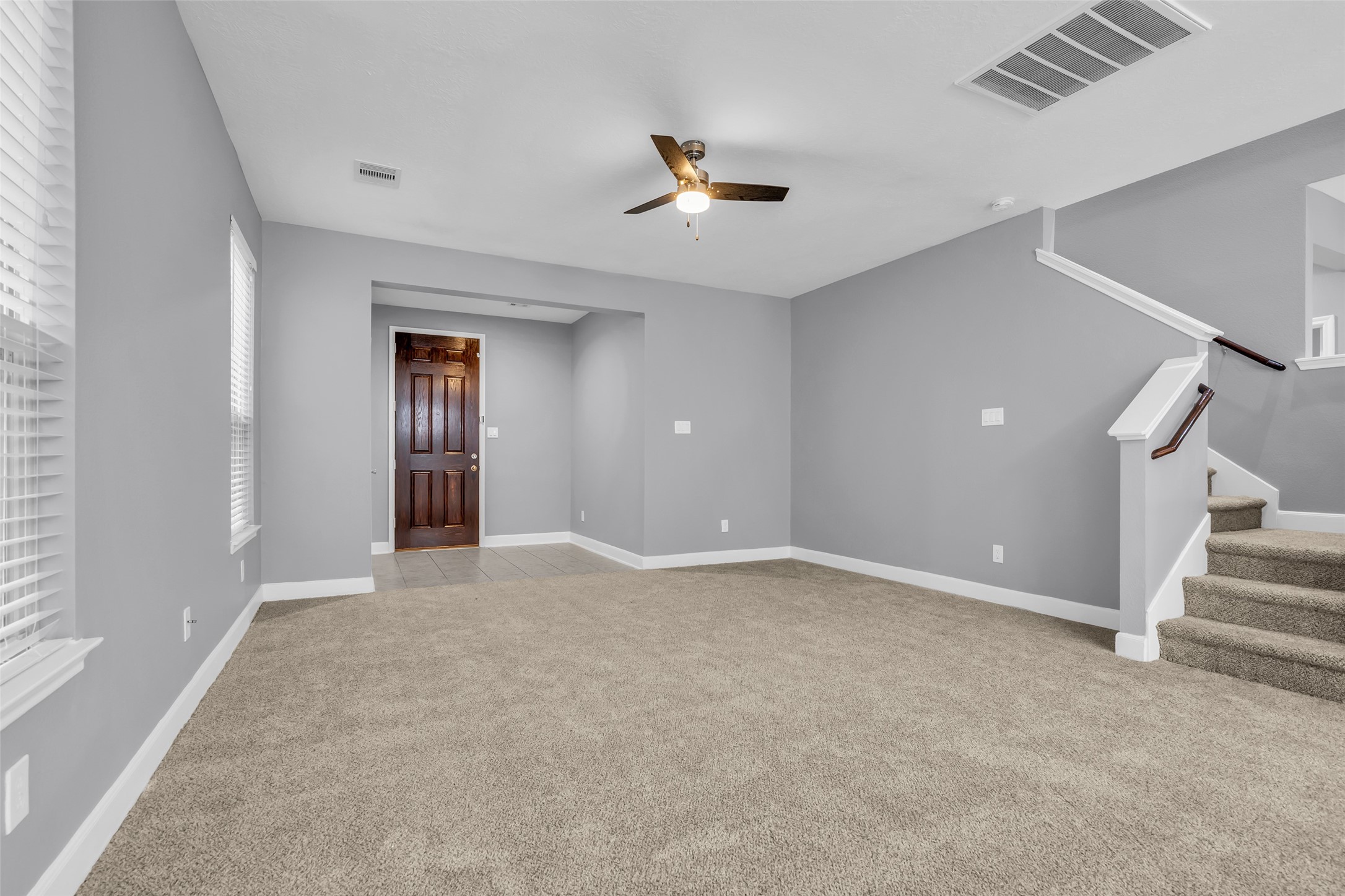 2707 Volute Houston, TX 77038 - Photo 5 of 28 Just past the foyer, the living room opens directly to the kitchen, creating a connected layout. This area features a carpeted flooring for added comfort.