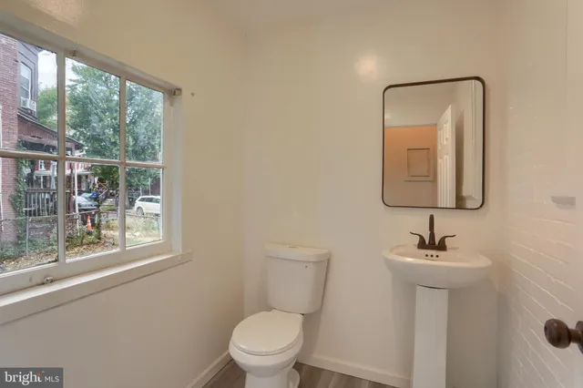 a bathroom with a toilet a sink and a window
