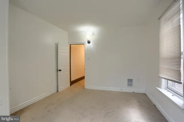 an empty room with windows and wooden floor