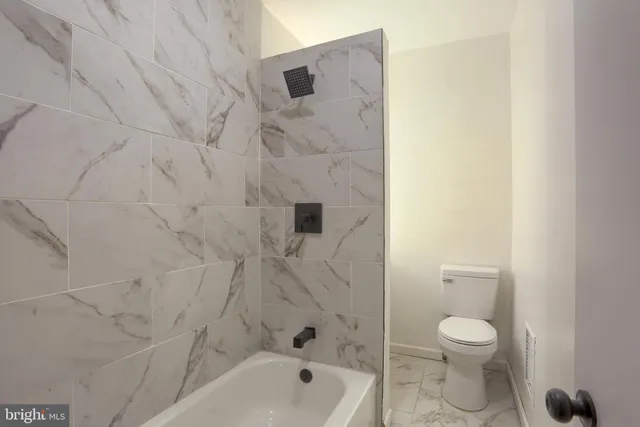 a bathroom with a toilet and a shower