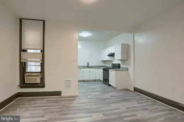 a kitchen with a refrigerator and white cabinets